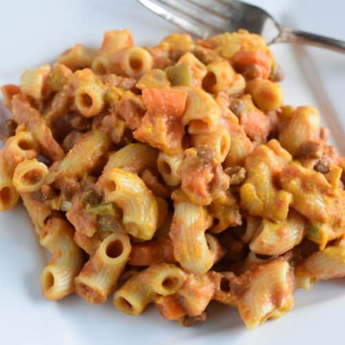 some of the casserole on a white plate with a fork next to it