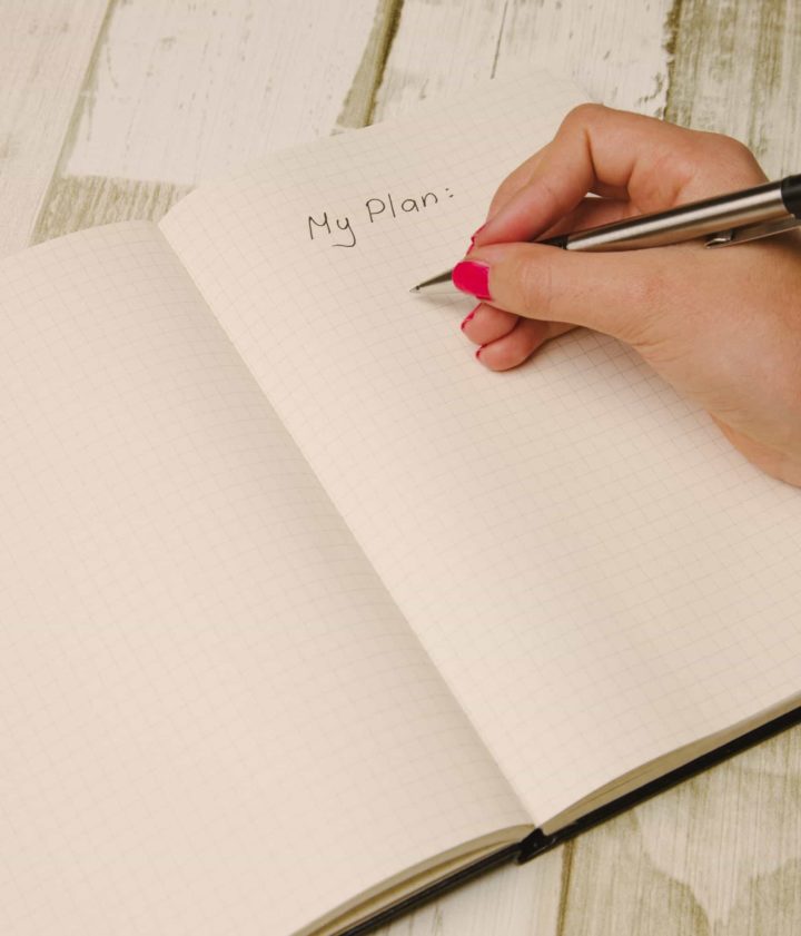 hand with pen about to write in notebook under the words "My Plan"