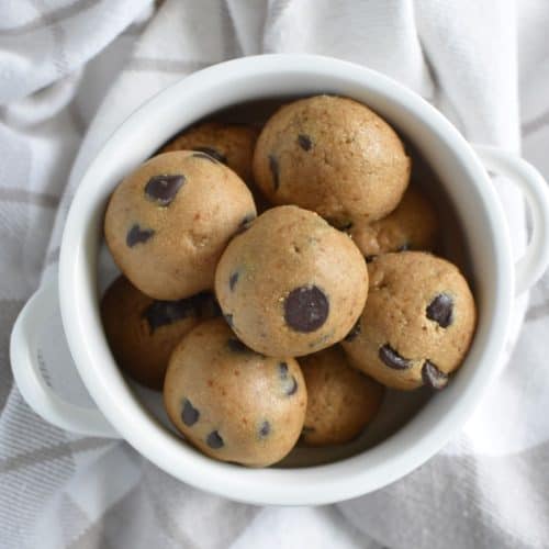 overhead of dough balls in a small white bowl on a kitchen napkin