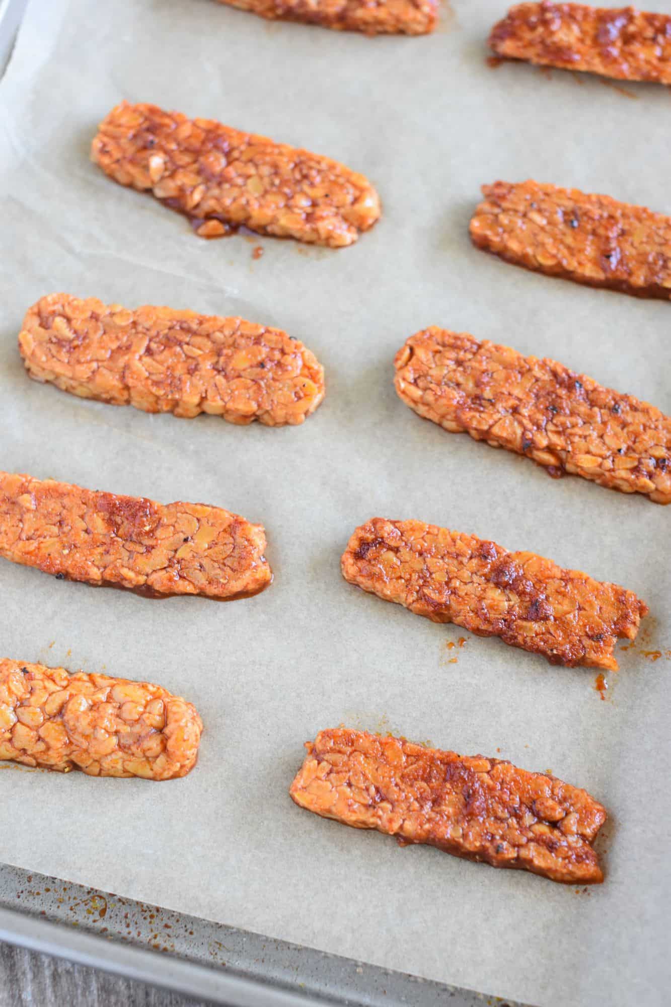 tempeh strips on parchment-lined baking sheet before being cooked