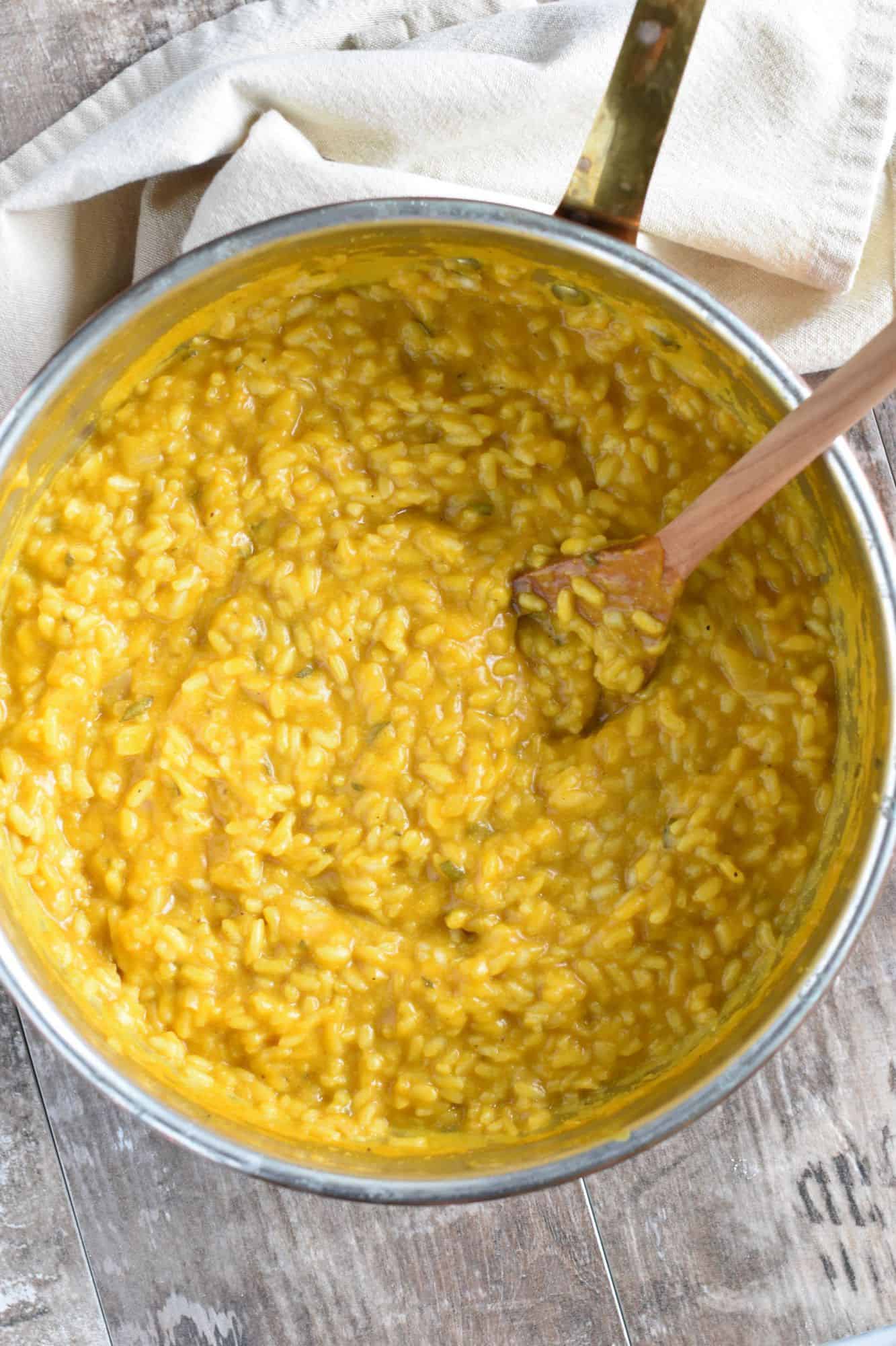 Overhead of finished risotto in pan with risotto spoon in it