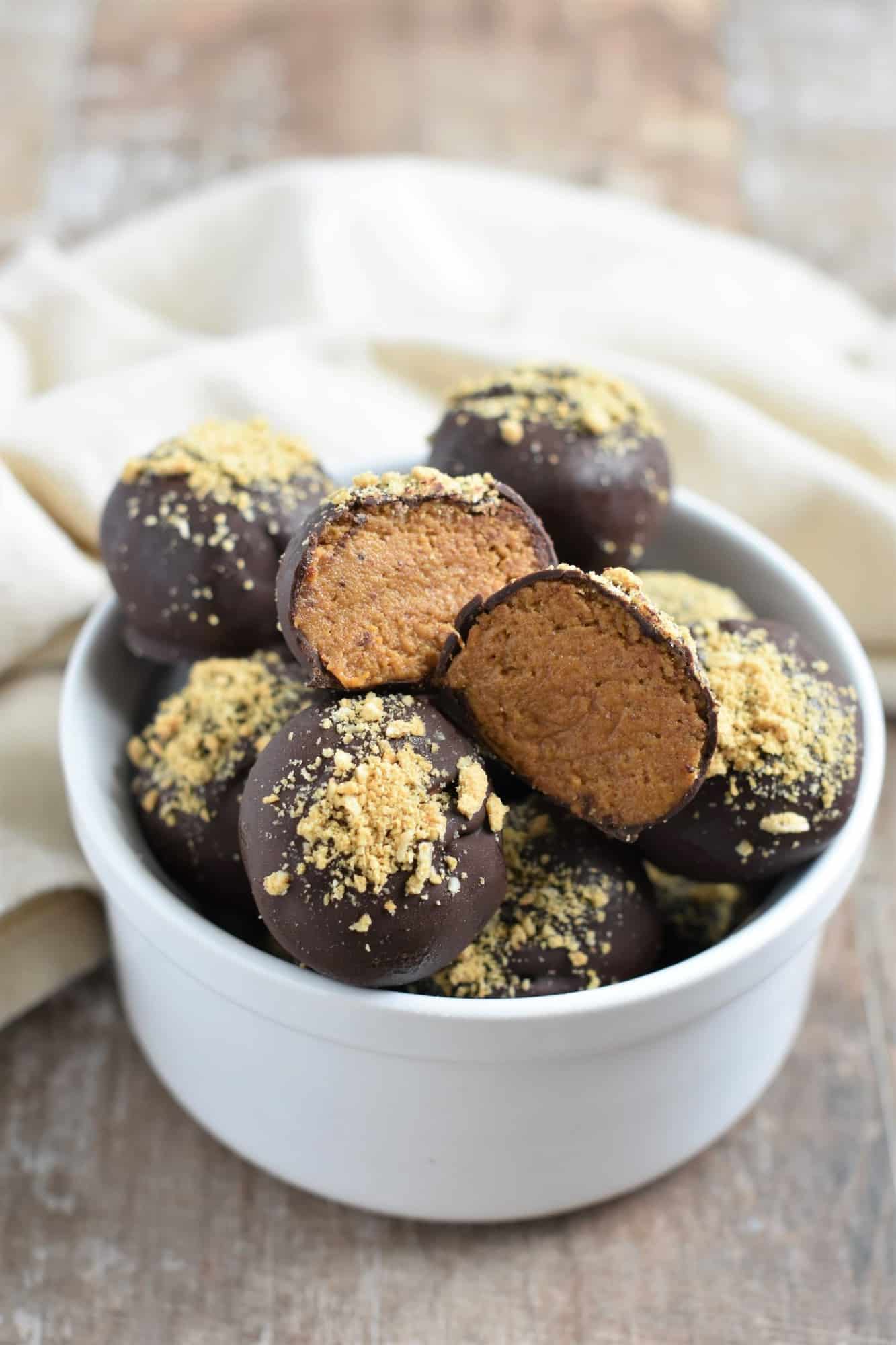 open truffle showing inside on top of other truffles in a white bowl