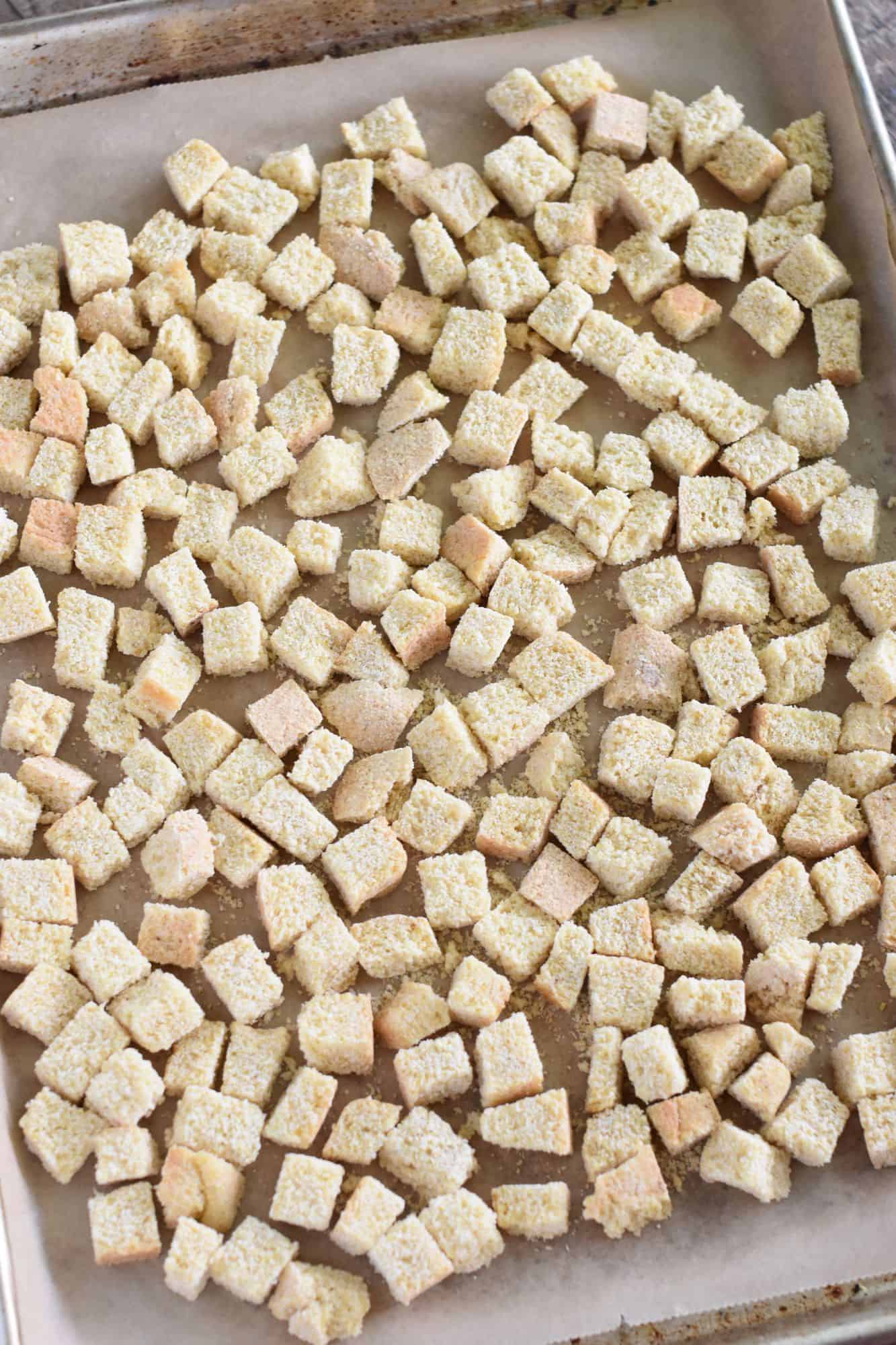 cubed gluten-free bread on parchment-lined baking sheet