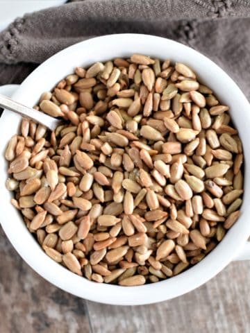 overhead of seeds in white bowl with spoon