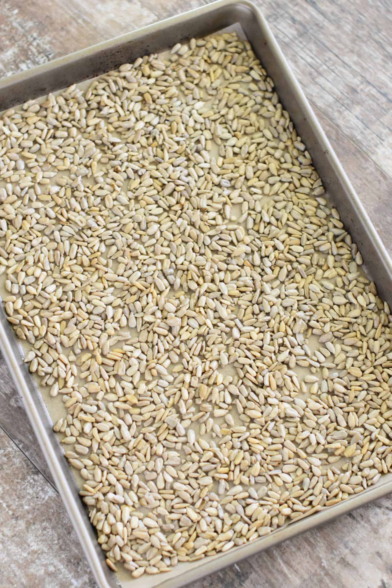 oil-coated and salted kernels spread out on baking sheet