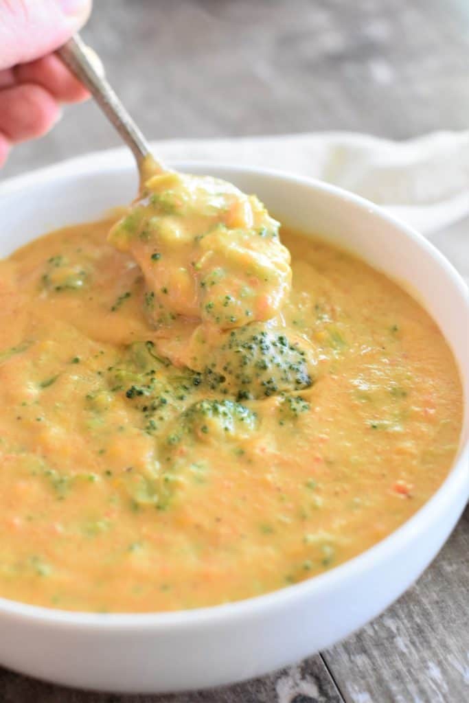 holding spoonful of soup over bowl of soup