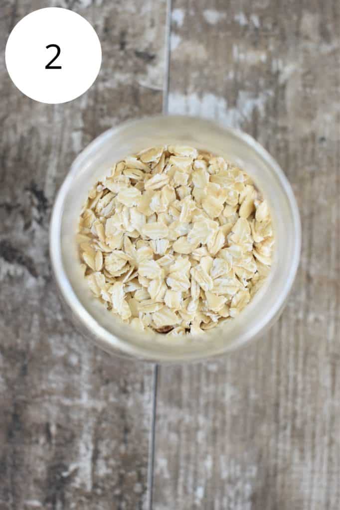 overhead shot showing oats added to the mason jar of ingredients