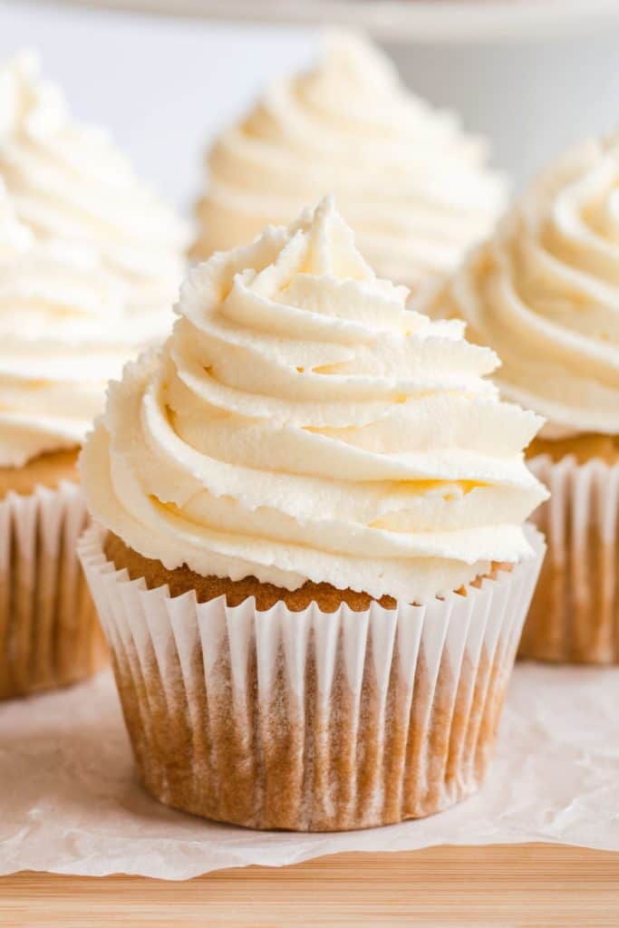 close-up of one frosted cupcake with some more blurred out behind it