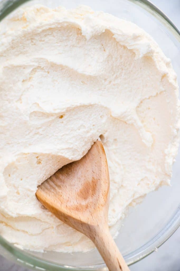 wooden spoon in mixing bowl of frosting