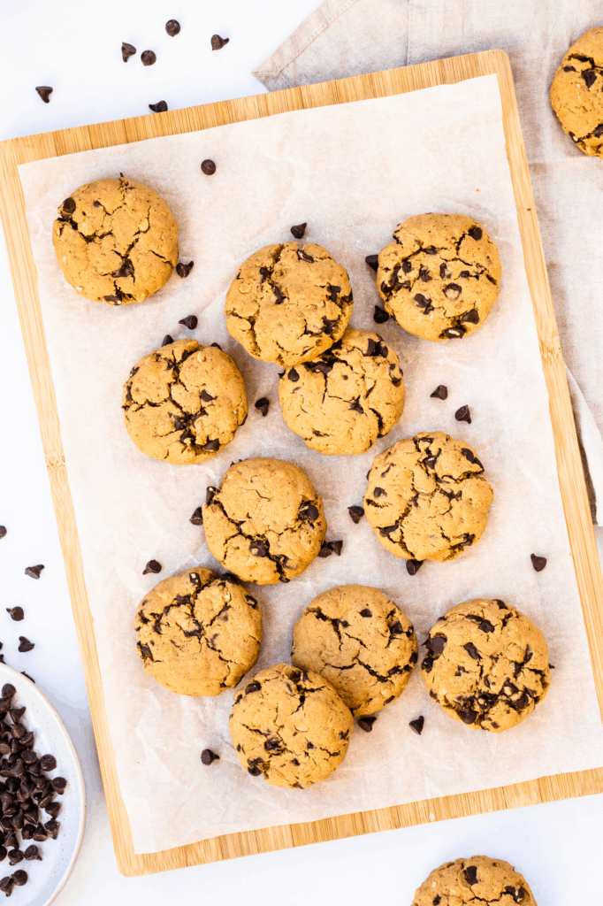 overhead of cookies on parchment paper on a wooden board