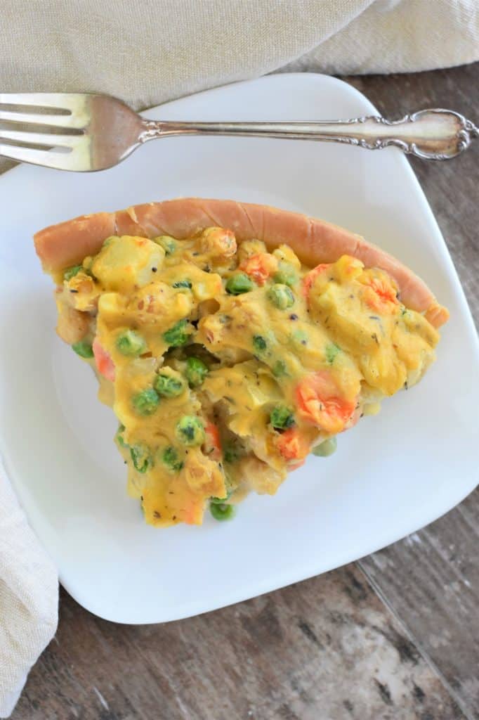 overhead slice of pot pie on a white plate with fork behind it