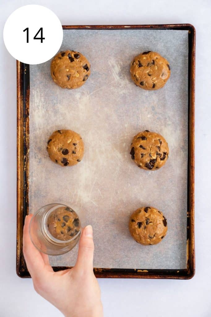 pressing down on a dough ball with a glass