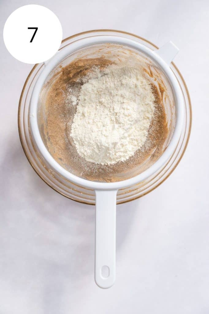 sifting flour mixture into the mixing bowl