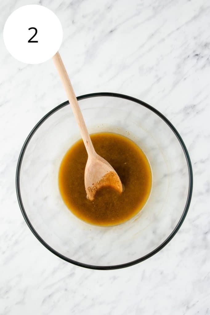 wet ingredients in mixing bowl with wooden spoon after being combined