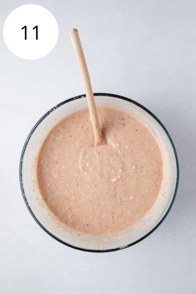 dry and wet ingredients combined in a mixing bowl with a wooden spoon