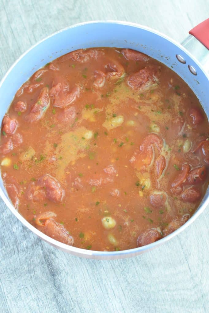 soup cooking in pot with vegetable broth, chickpeas and pasta added.