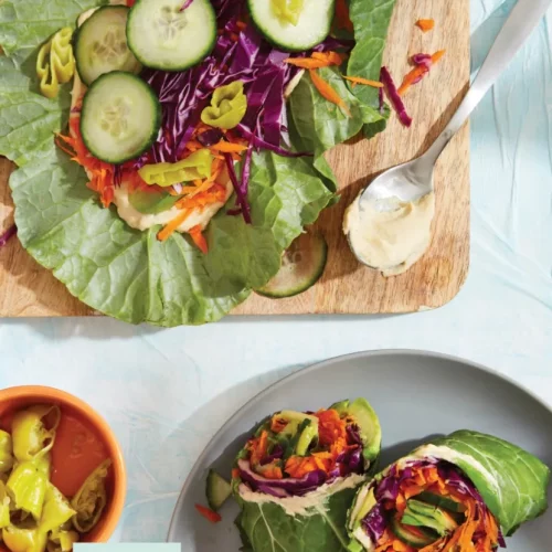 rainbow collard wrap cut in half on a plate.