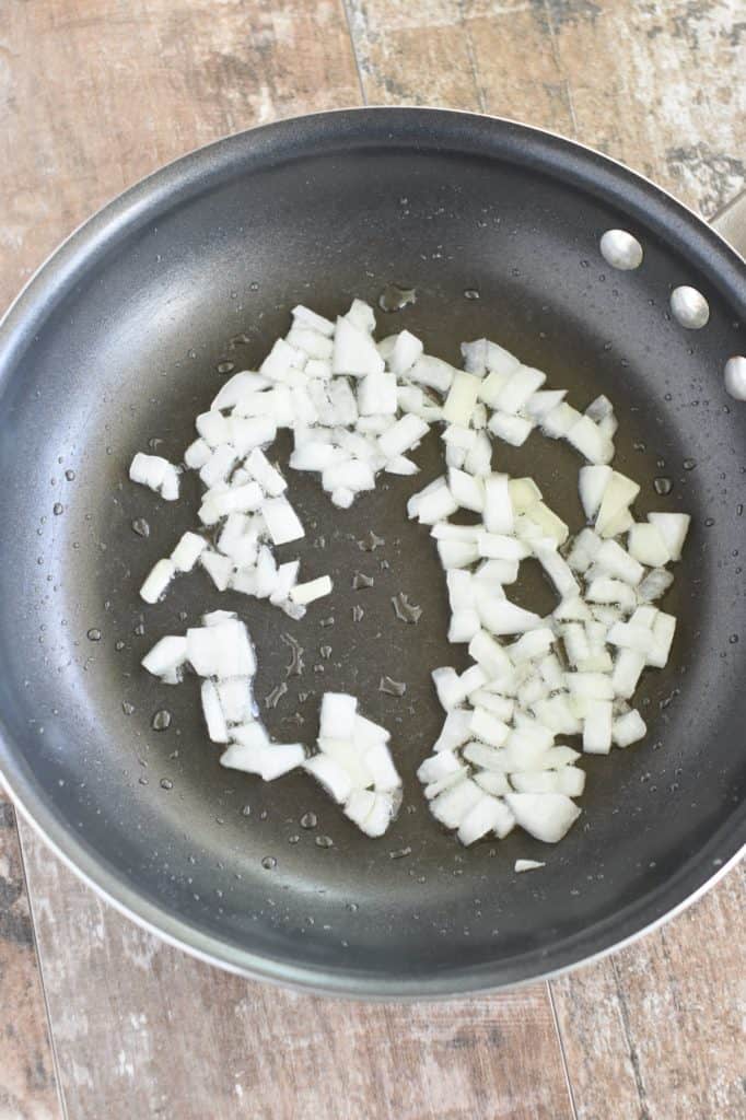 chopped onion cooking in olive oil in a pan