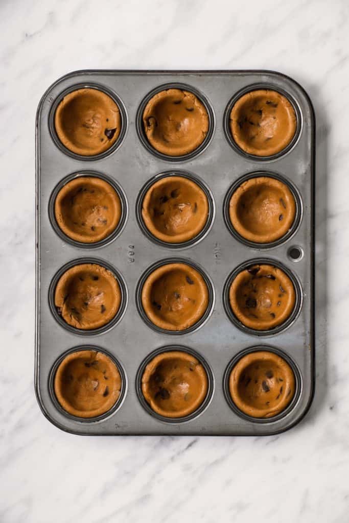 dough in mini muffin tin after pressing