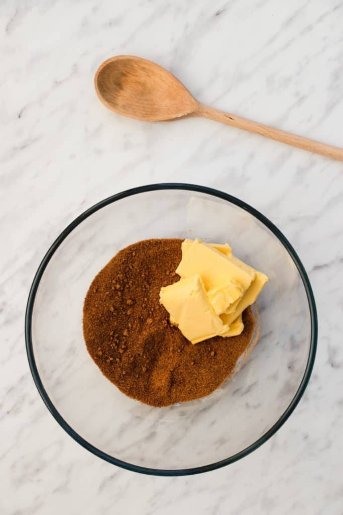 vegan butter and coconut sugar in bowl with wooden spoon behind it