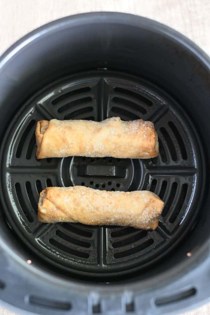 frozen egg rolls in air fryer basket before cooking