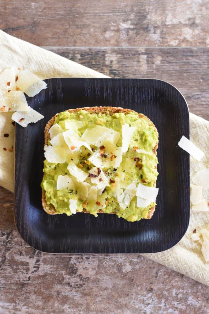 overhead of slice of avocado toast with Parmesan and crushed red pepper flakes