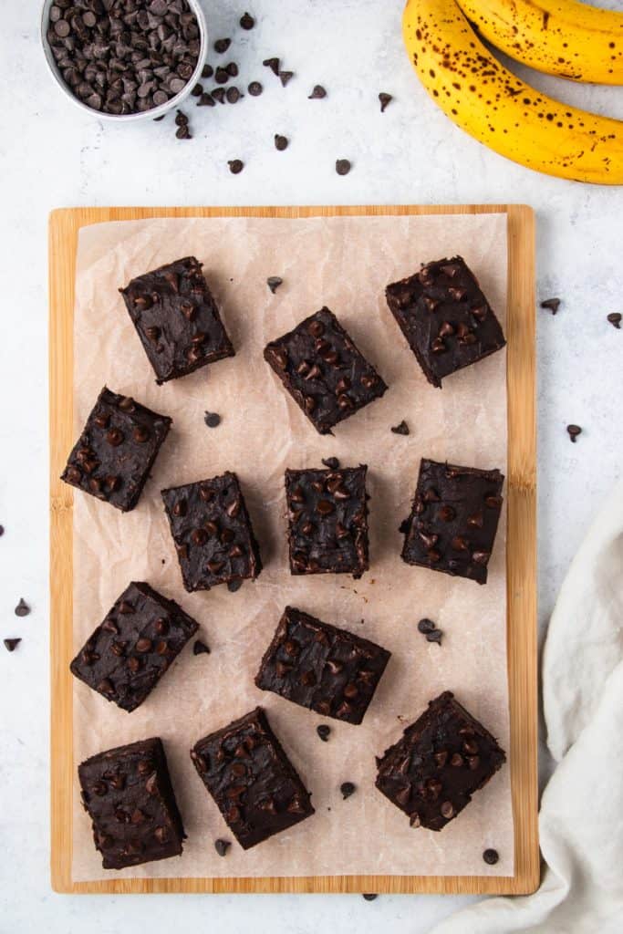 overhead of brownies after being cut on parchment on a wooden board