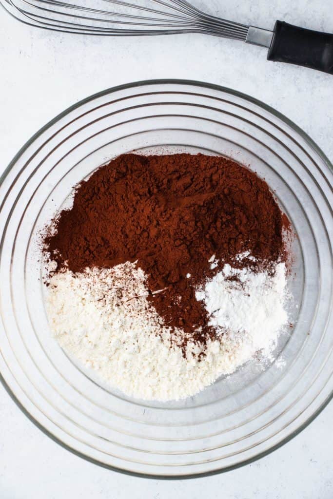 overhead of dry ingredients in mixing bowl with whisk behind it