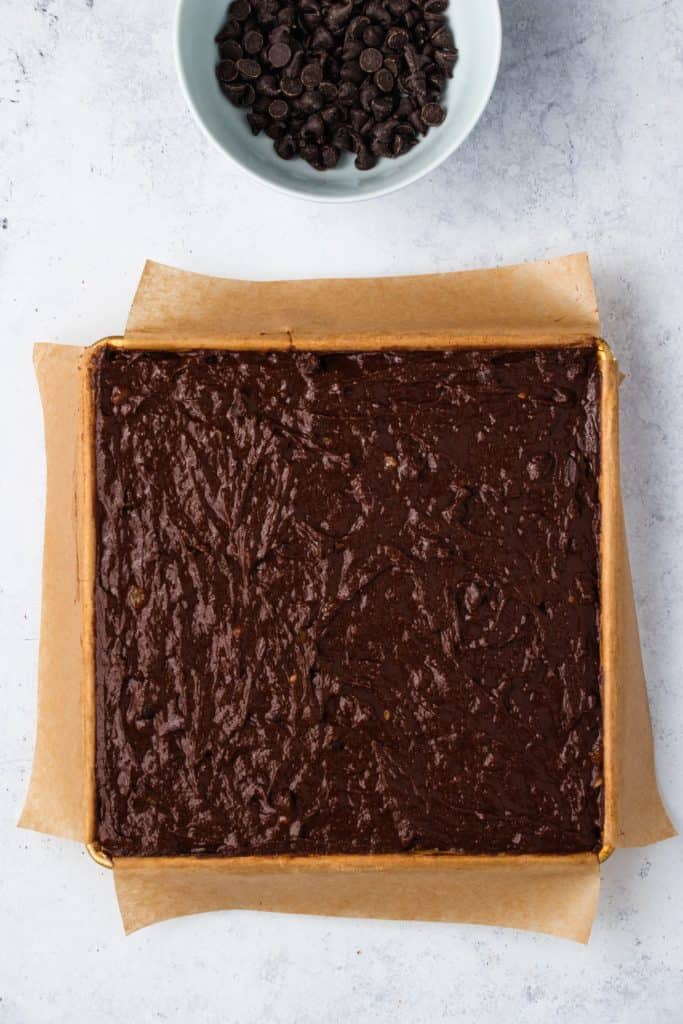 brownie batter added to lined baking dish