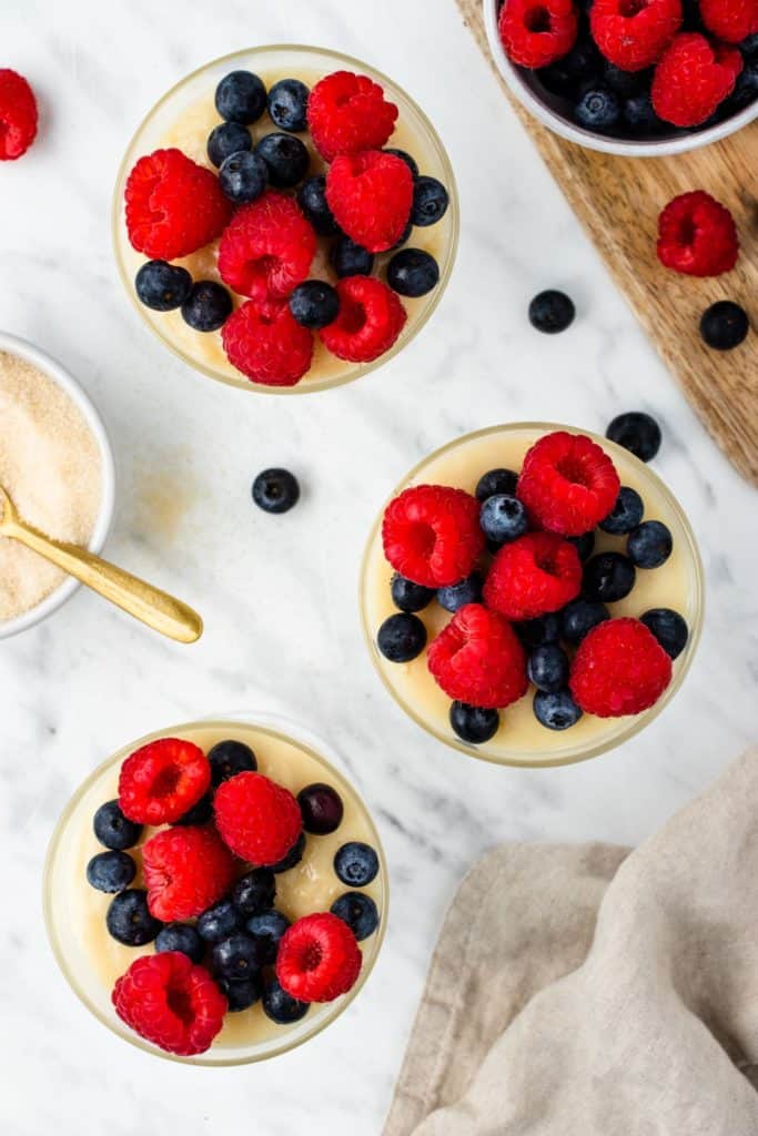 overhead of three servings of pudding with fruit