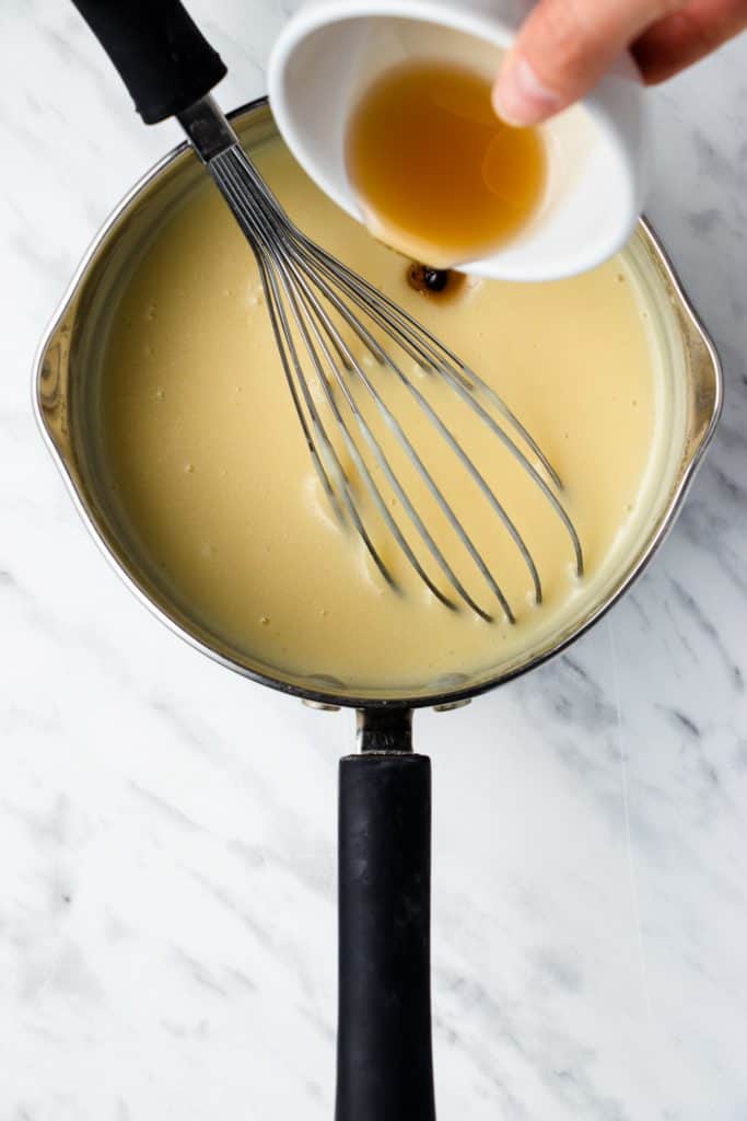 adding vanilla into the mixture in the saucepan