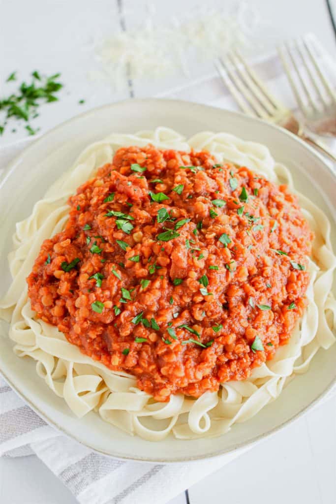 close-up overhead of tagliatelle pasta topped with sauce and sprinkled with parsley