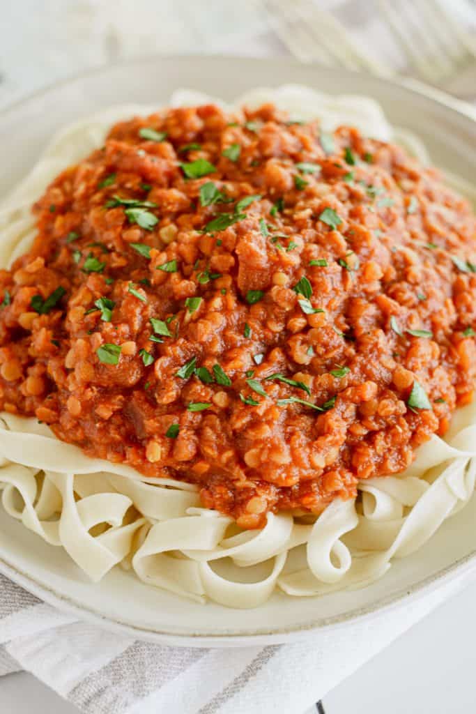 close-up of serving of pasta with sauce topped with fresh parsley