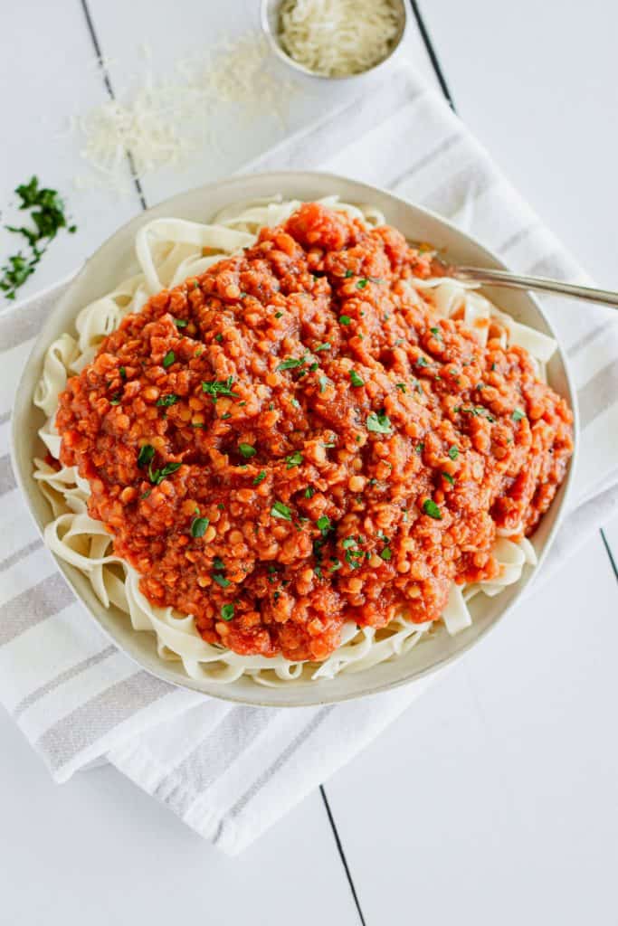 overhead of serving of pasta with sauce with fork in it on the right and garnished with parsley