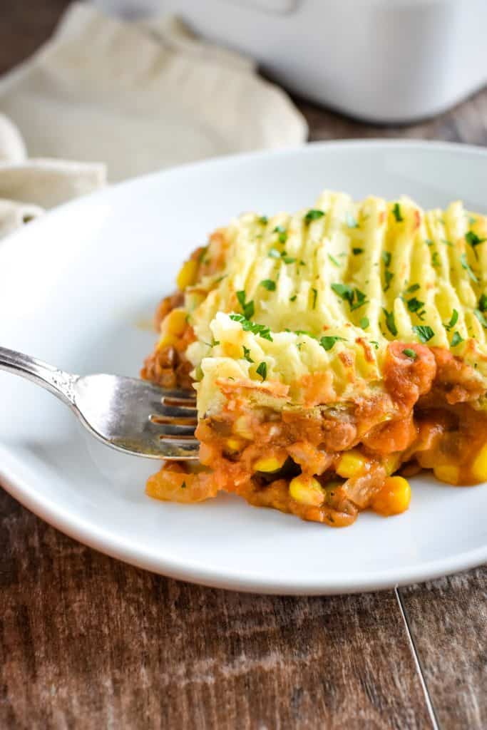 fork grabbing some of a slice of shepherd's pie on a plate