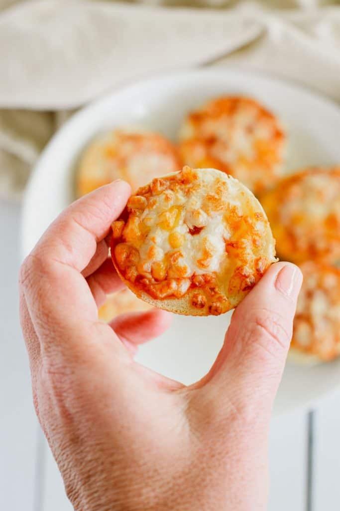 hand holding up a bagel bite