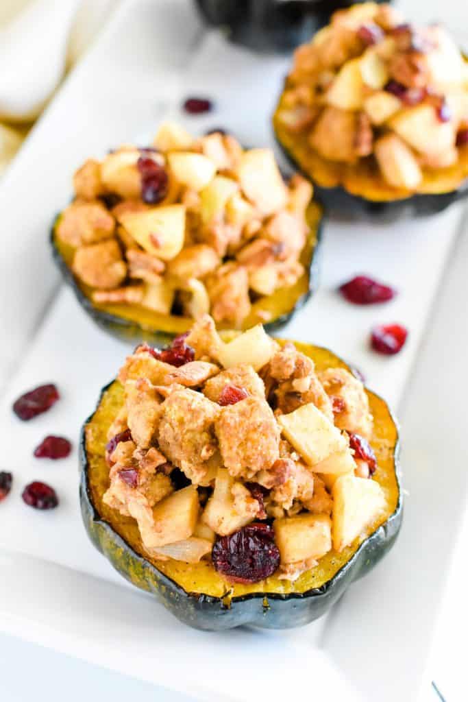 slight overhead view of serving of acorn squash on platter with 3 more blurred out on the platter