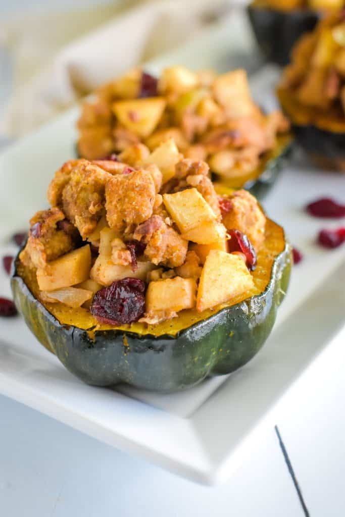 front close-up view of 1 acorn squash serving on platter with more servings blurred out behind it