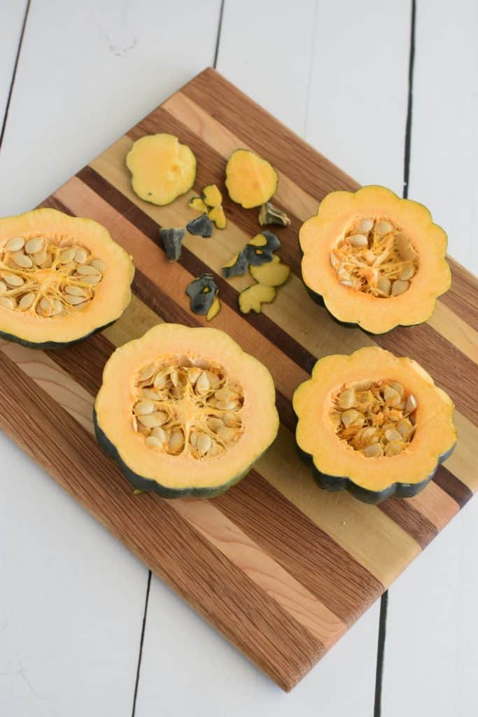 4 cut acorn squash halves on wooden board