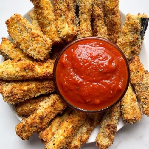 eggplant Parmesan fries on white plate with side of marinara