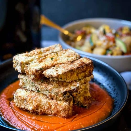 eggplant in a bowl of roasted red pepper sauce