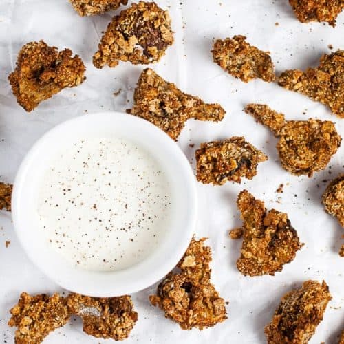 overhead of air fried mushrooms on parchment paper with side of dipping sauce