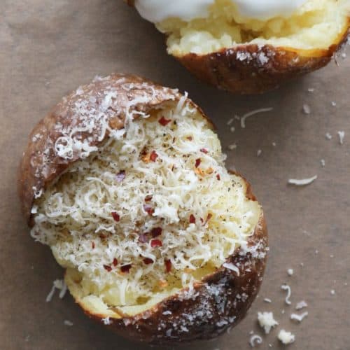 overhead of baked potato topped with Parmesan and red pepper flakes