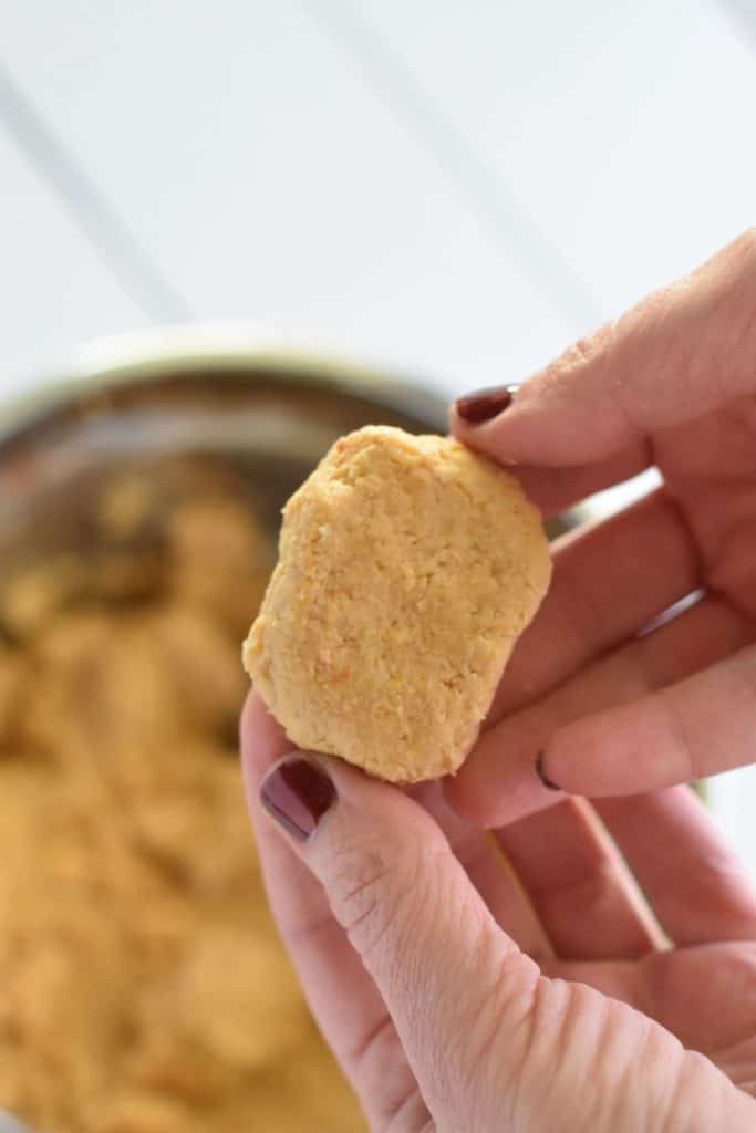 holding up a shaped nugget over the mixture