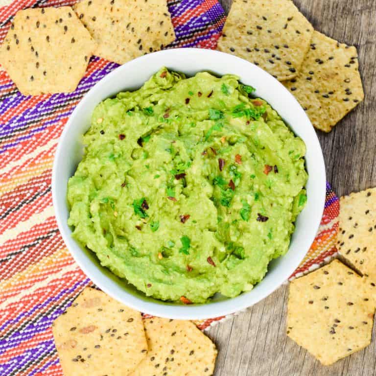 close-up overhead of guacamole in white bowl.