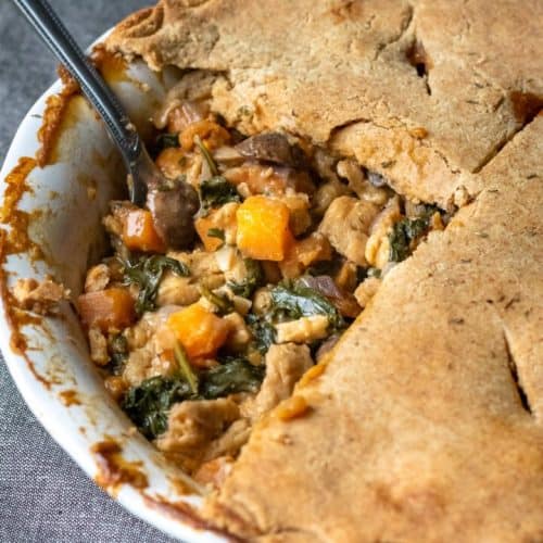 overhead of pot pie with spoon in it scooping out some revealing the inside.