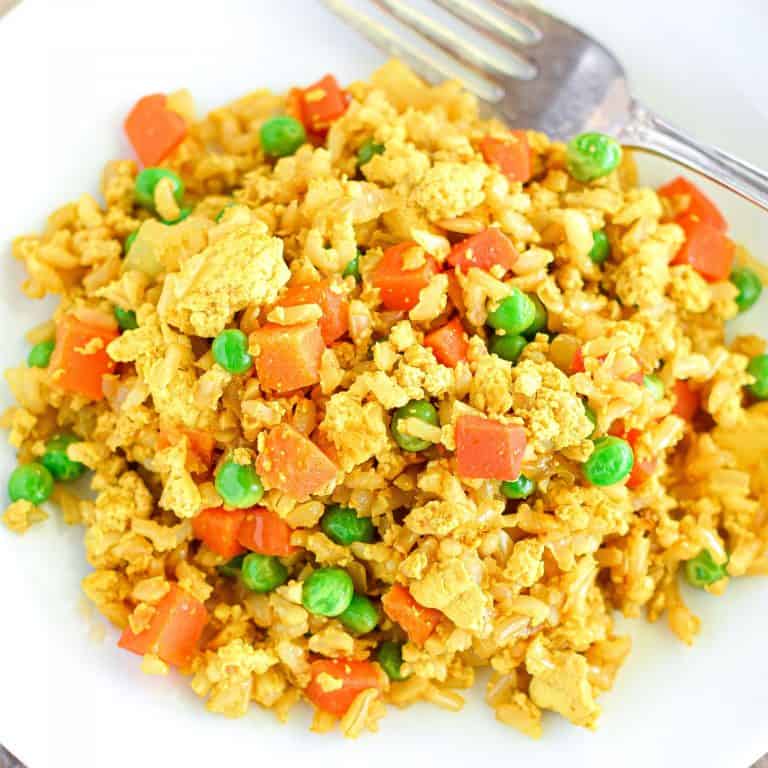 close-up of fried rice on white plate with a fork.