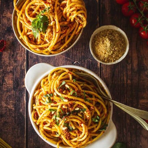 overhead of pasta in white crock with a fork and spoon in it.