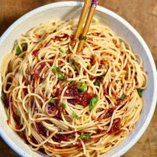 overhead of chili garlic noodles in a bowl with chopsticks.