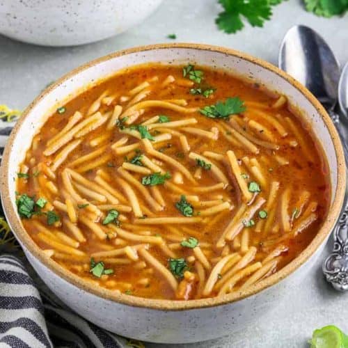 Mexican noodle sop in a bowl with one partially in view behind it.